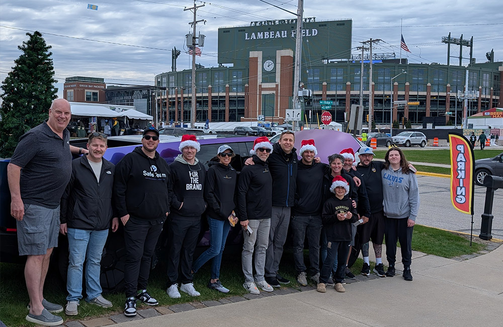 Group photo in front of purple truck at Lambeau Field