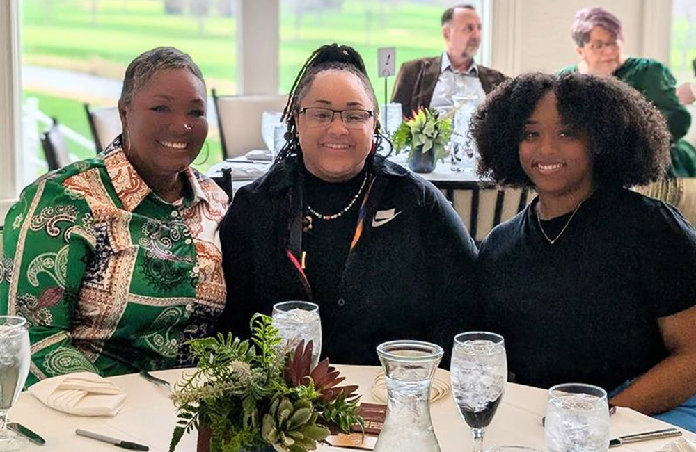 Three women smiling at dinner table